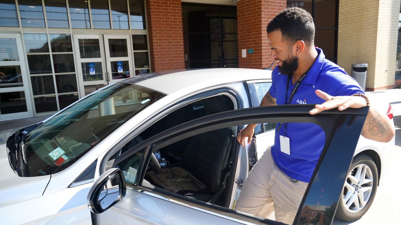 Roswell Park valet attendant gets into a silver car outside the main entrance