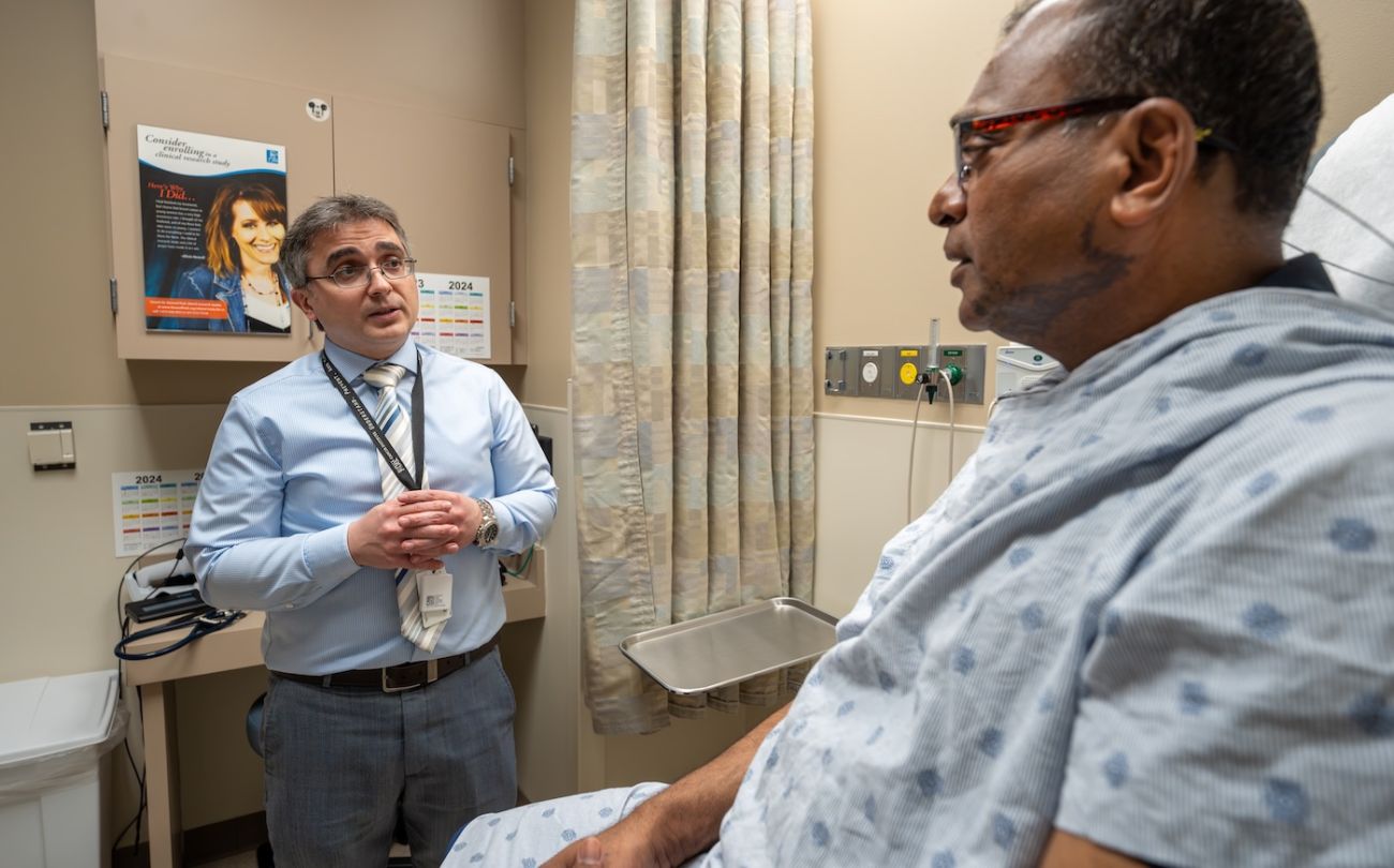 Dr. Christos Fountzila speaks with a male patient