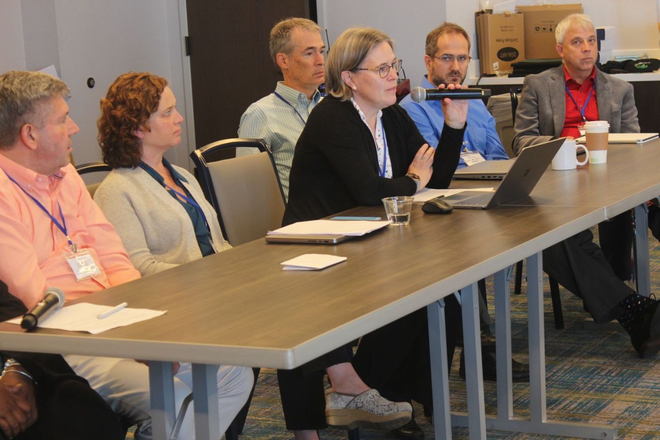 A woman speaking into a microphone at a conference