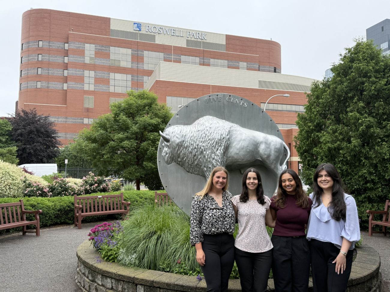 4 residents in the Oncology Pharmacy Residency program smile for a photo with Roswell Park in the background