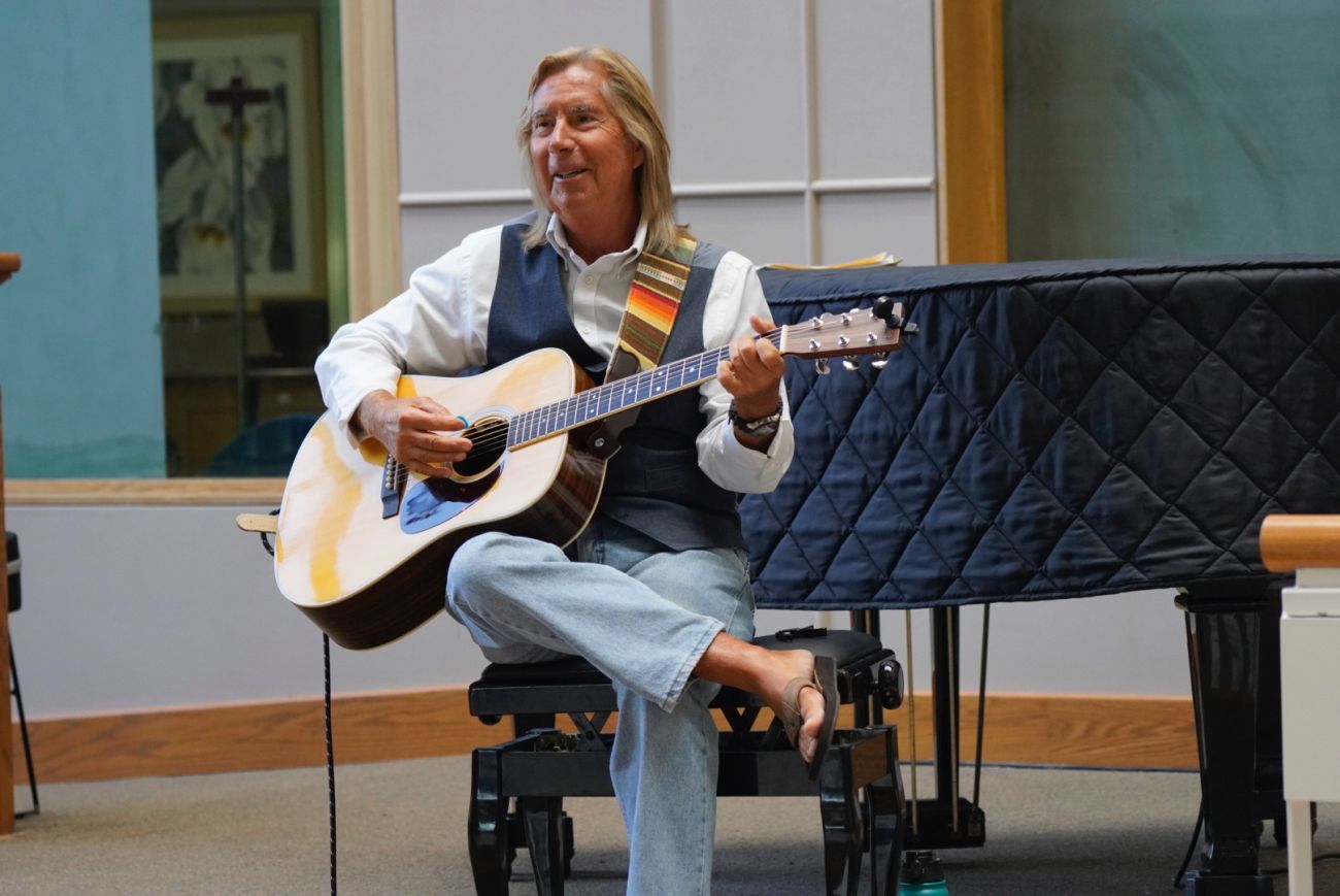 A man playing a guitar in a hospital lobby
