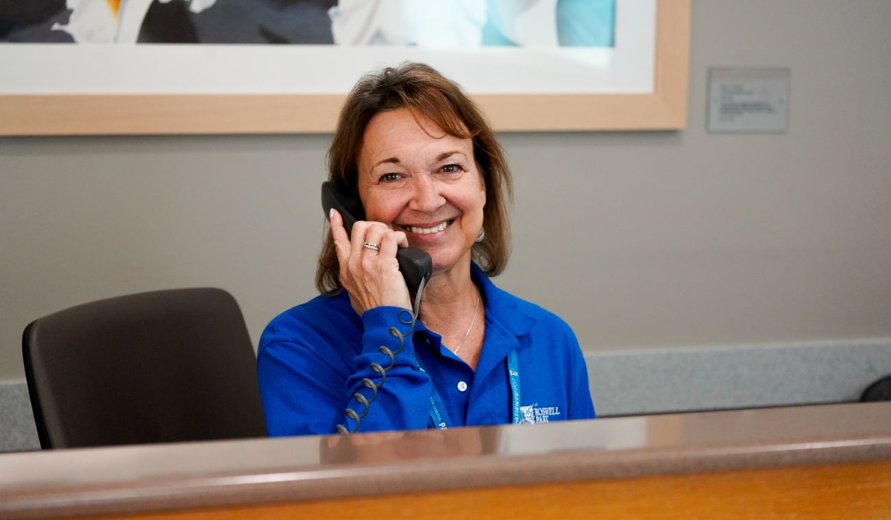 A smiling volunteer answering a phone