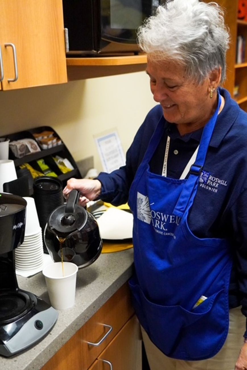 An elderly volunteer pouring coffee for someone in the hospital