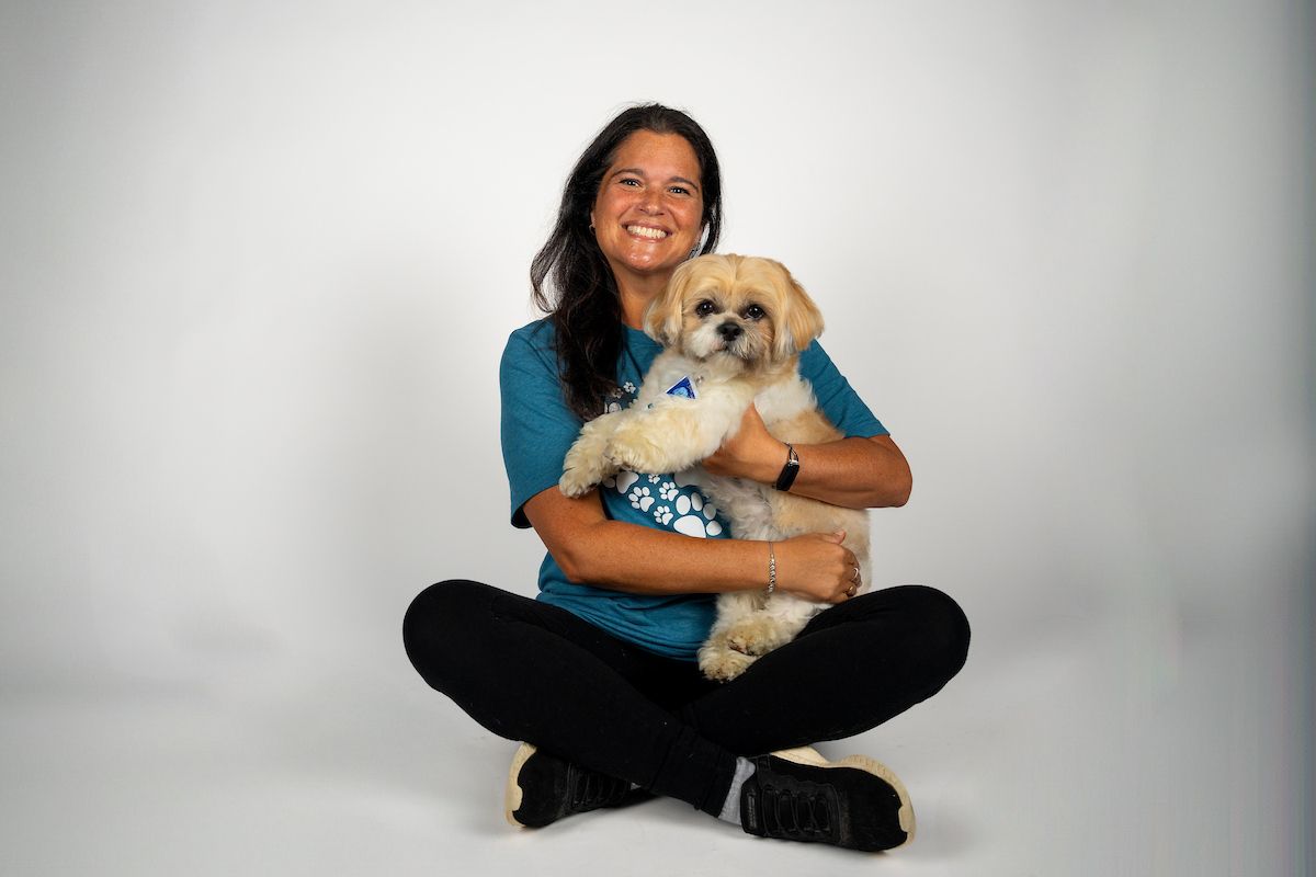 A Shih Tzu dog being held by their owner