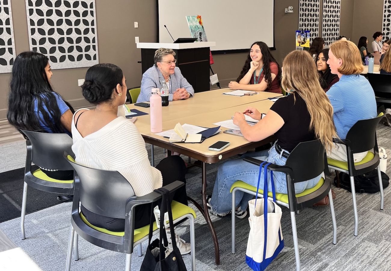 BHE students sit around a table and interview a patient for their Storyboard Project