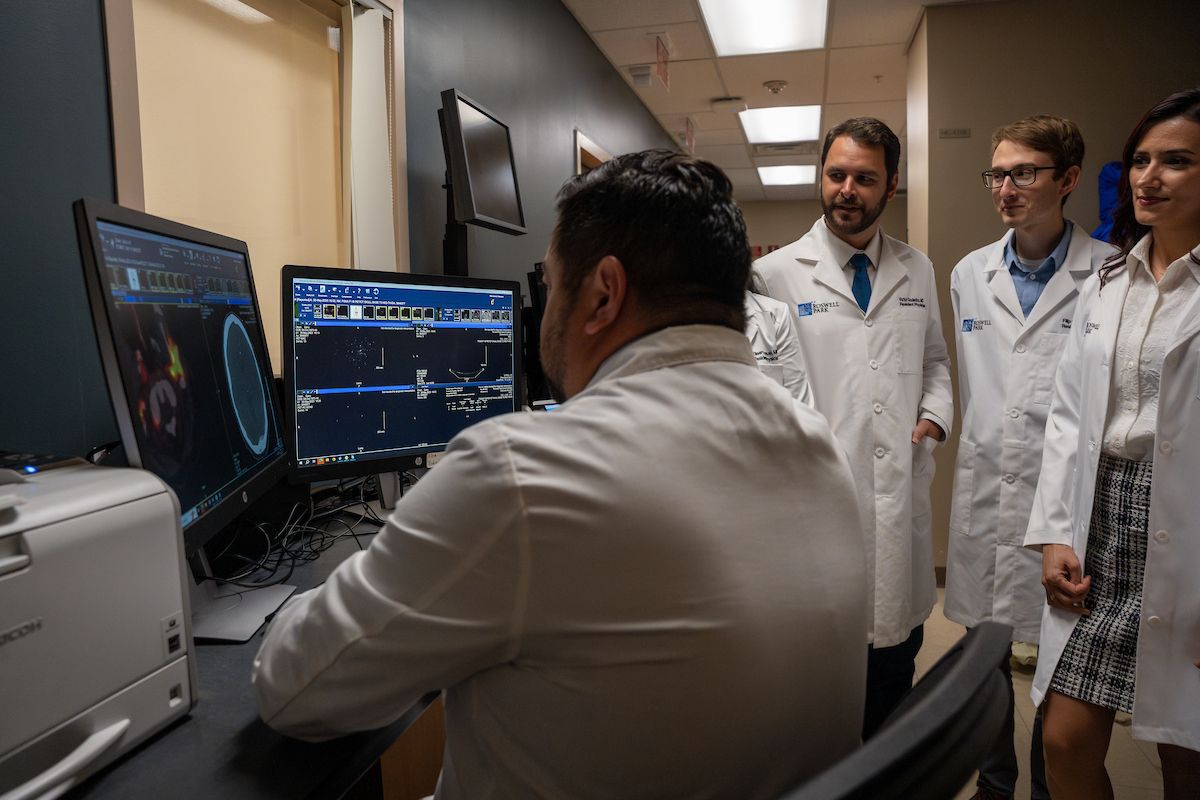 A group of residents in the radiation oncology program look at a scan with Dr. Fung Kee Fung