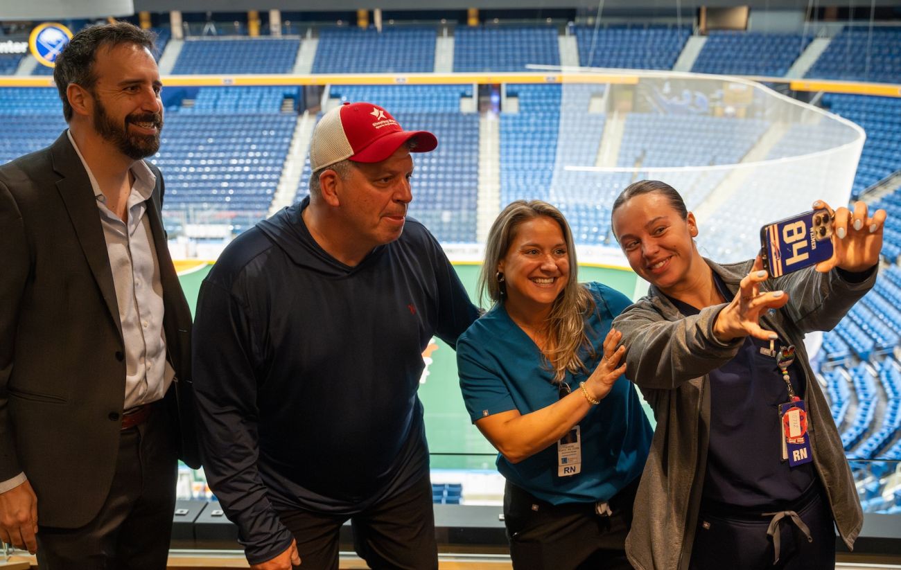 A doctor and nurses pose with a patient for a selfie