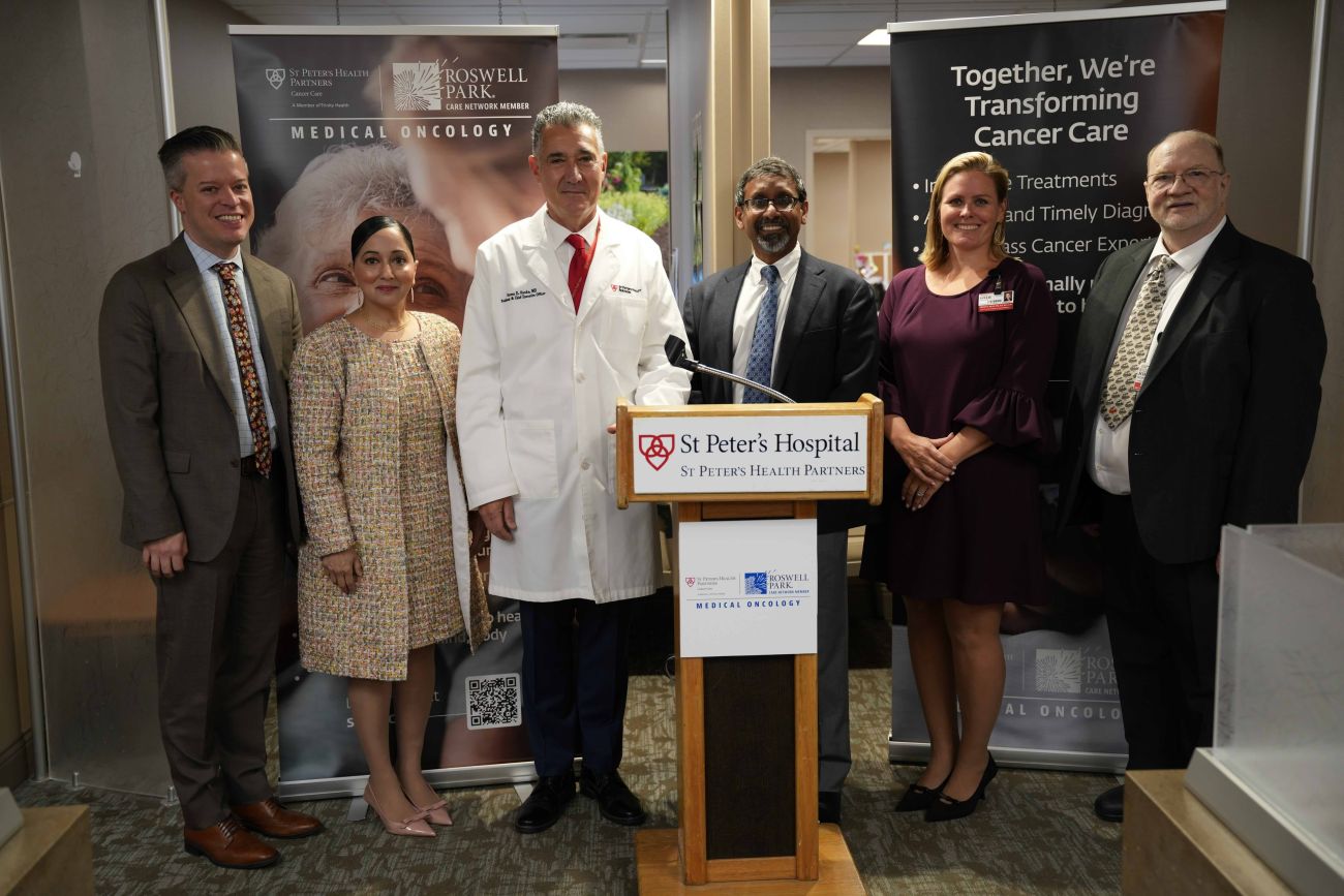 Leaders stand in front of podium for announcement
