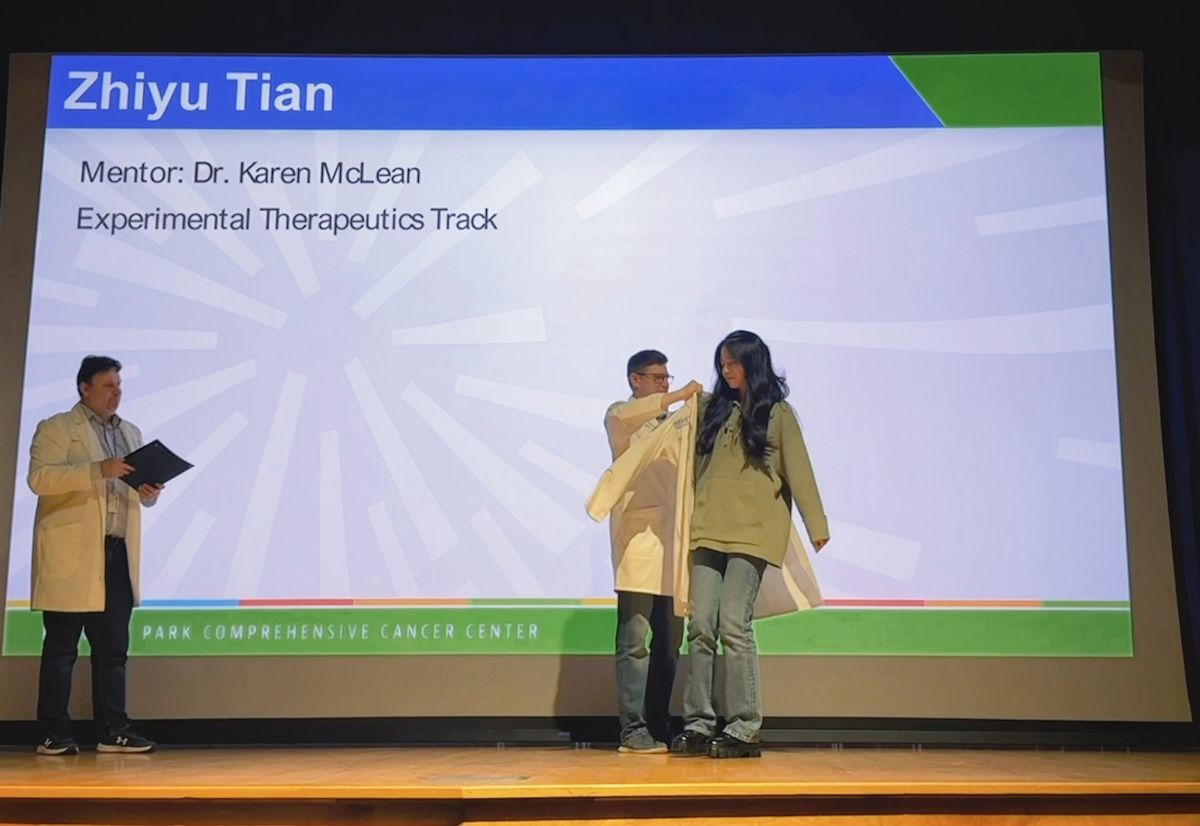 A scientist receives her "white coat" in a ceremony
