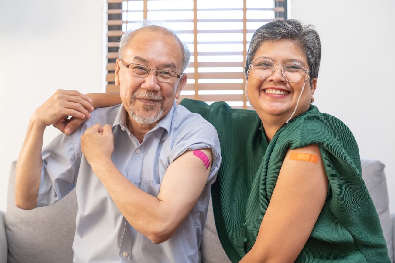 A couple shows off their vaccines with matching bandaids on their left arms