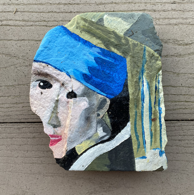 A rock painted to resemble the painting "Girl with a Pearl Earring", painted by lymphoma patient Heather Bucalos