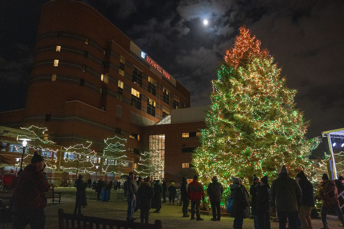 A holiday tree is lit beside a hospital