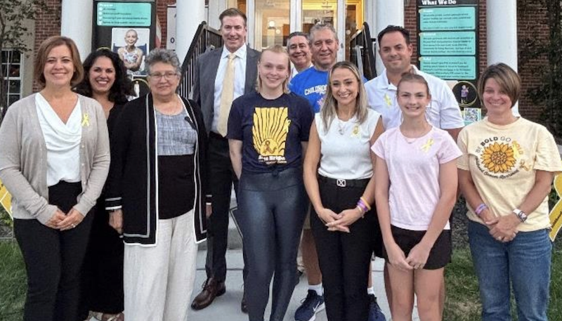 A presentation in honor of a pediatric cancer patient at a town hall.