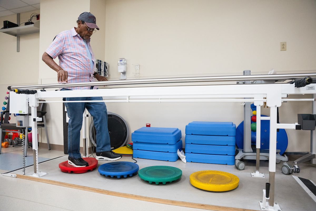 Older Adult Oncology Patient Nathaniel Fountain practices a balancing exercise in the Rehab Therapy center 