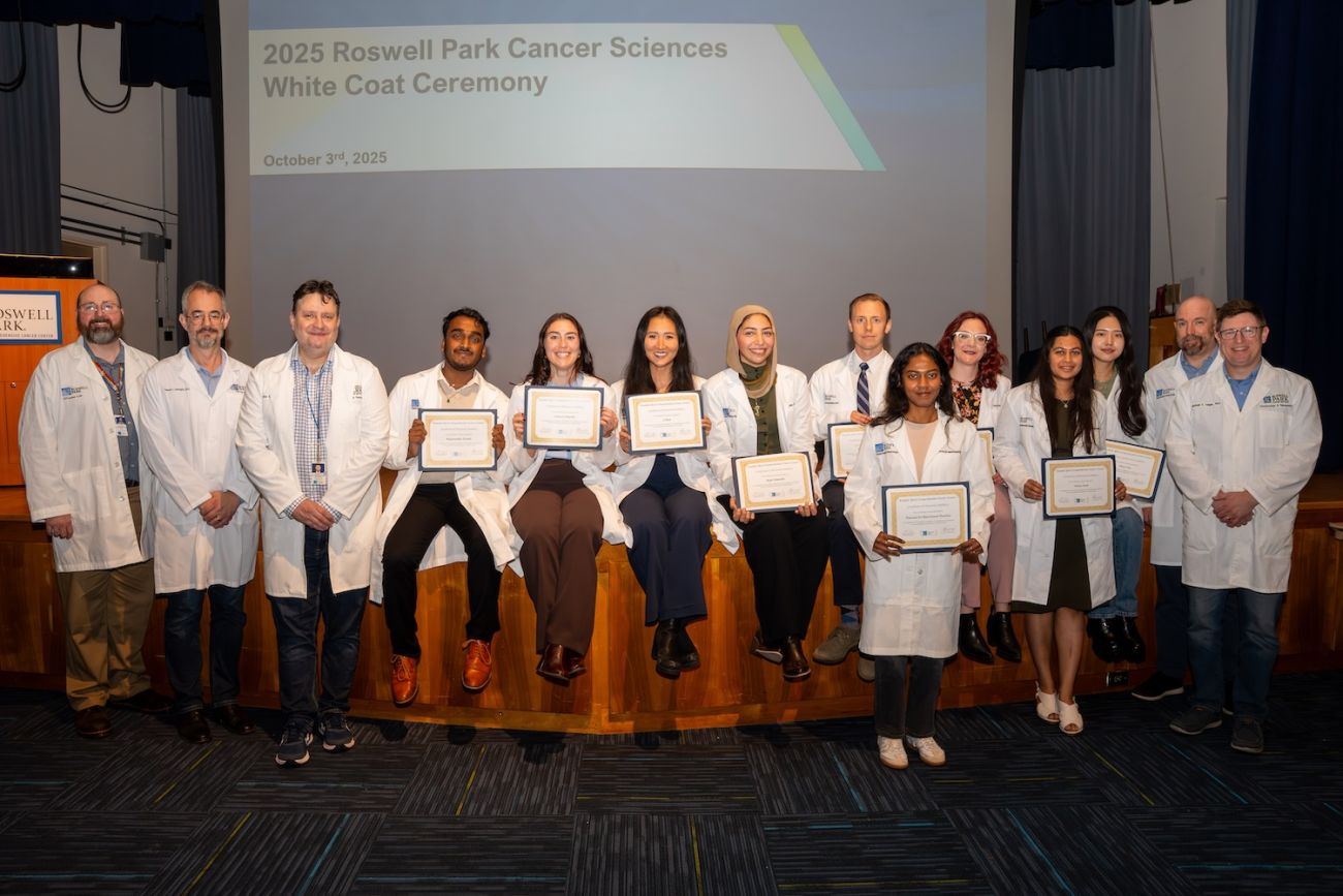 Roswell Park students sits in on a stage after their White Coat Ceremony 