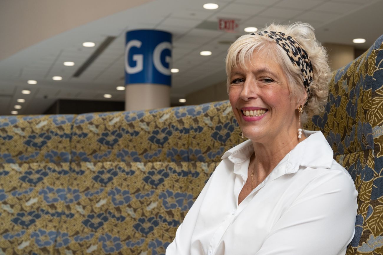 A woman smiles in the waiting room of a hospital
