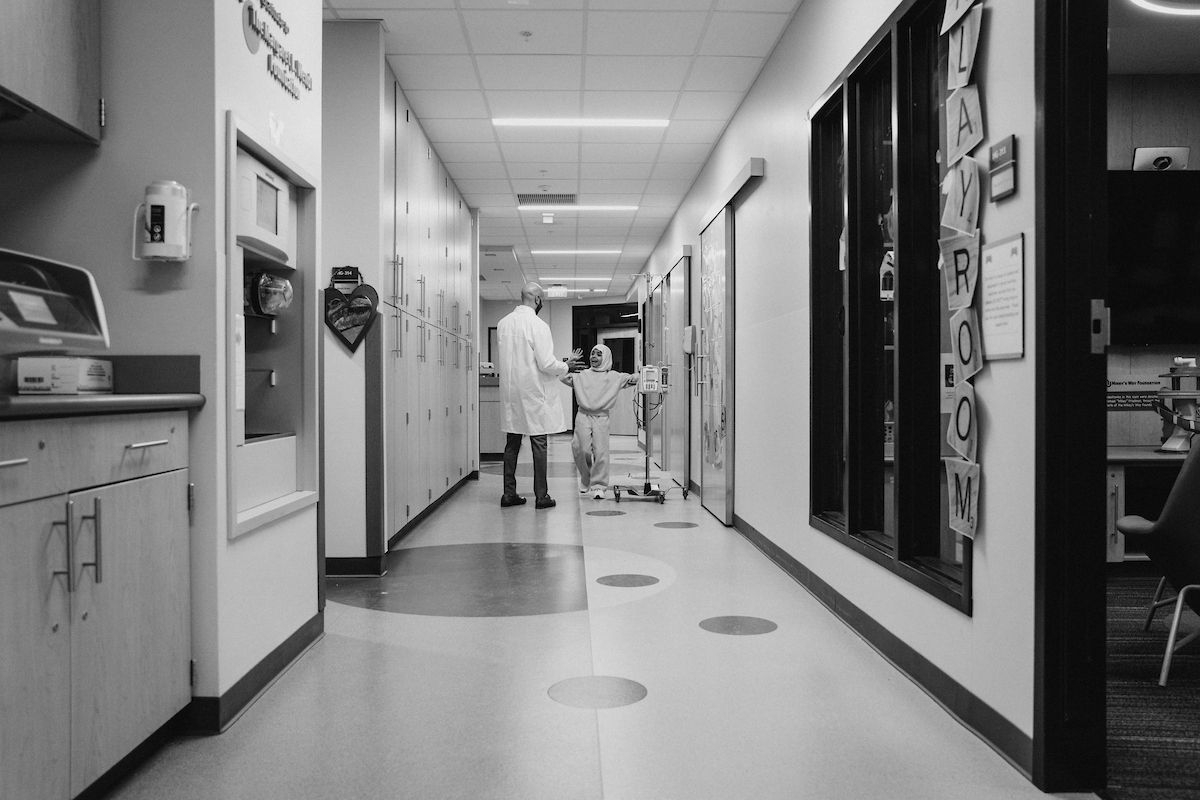 Dr. Ajay Gupta and pediatric patient Sana Hashemi high five in the pediatric clinic