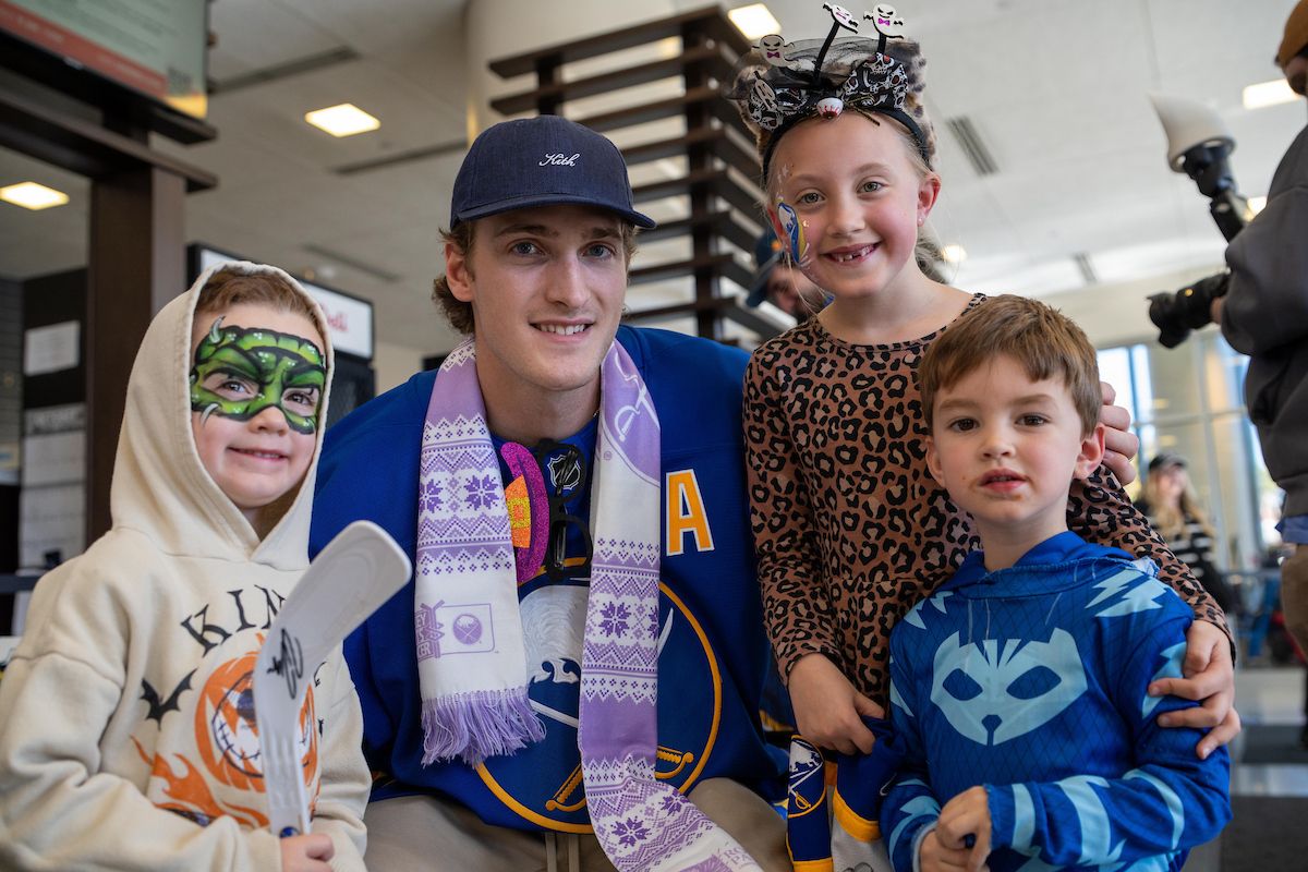 Hockey player Tage Thompson poses with pediatric cancer patients.