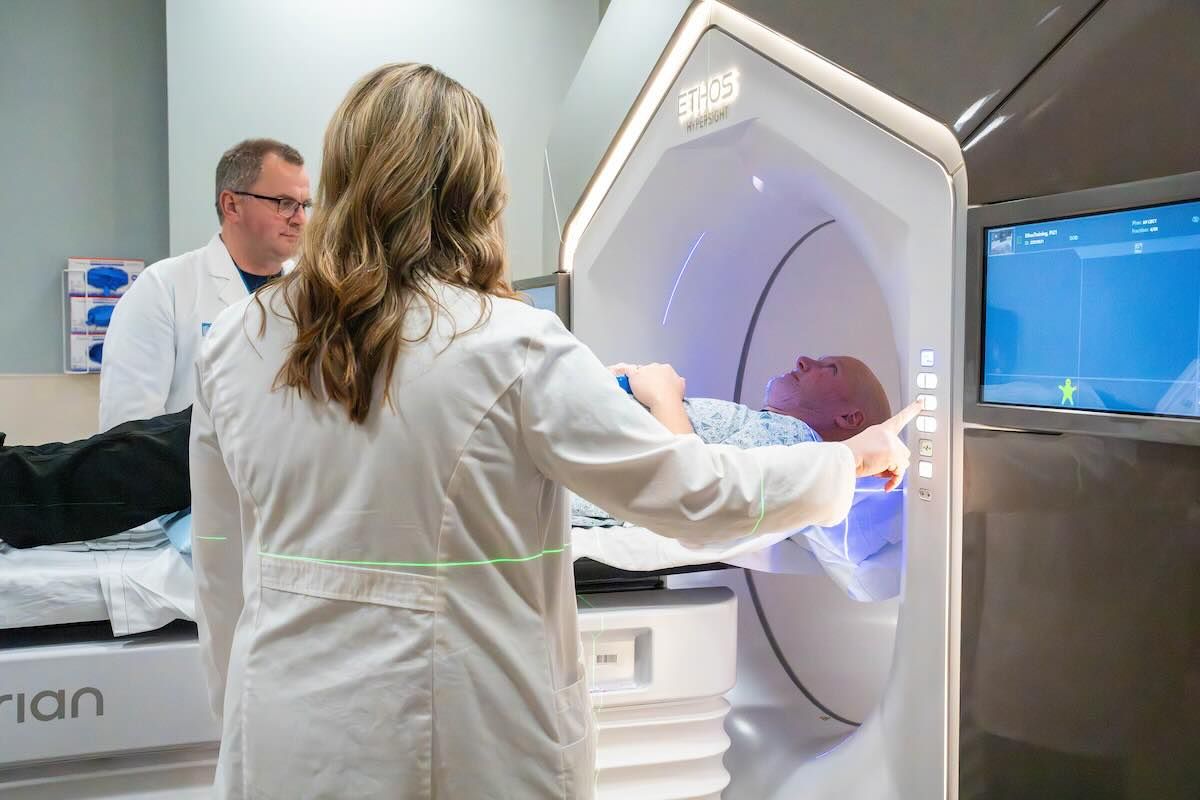 Two doctors with patient in radiation machine