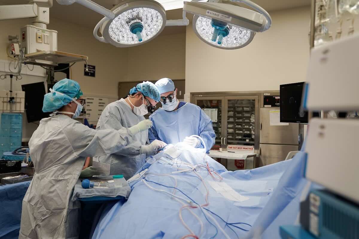 Three doctors performing surgery