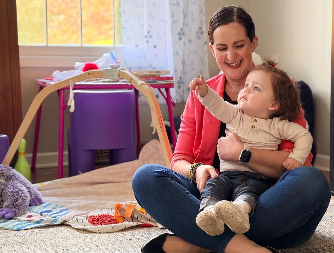 A mom sits with her child in her lap.