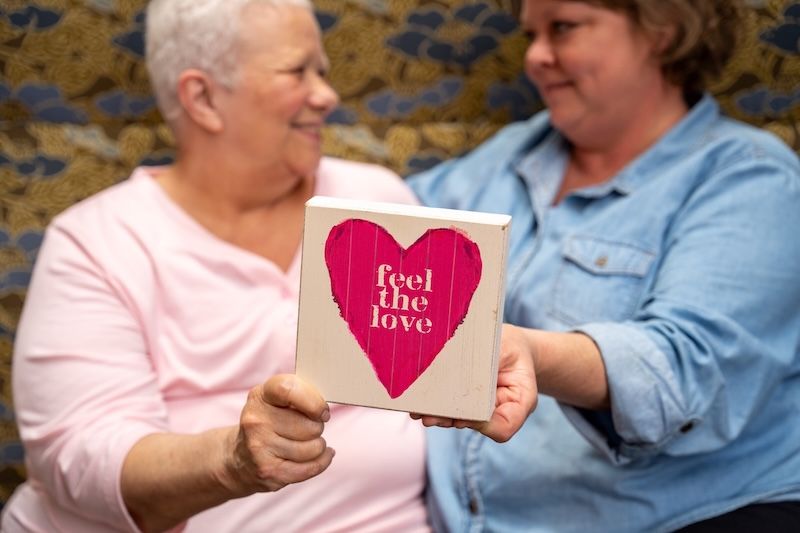 Breast and ovarian cancer patient SallyAnn Decker and her niece, Stacy, hold a heart sign