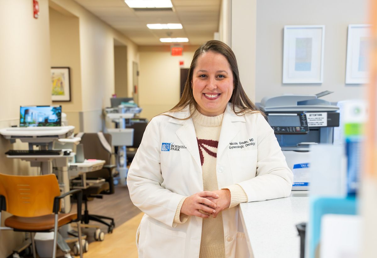 Gynecologic oncologist Dr. Nicole Gaulin smiles to the camera while wearing a white coat in clinic