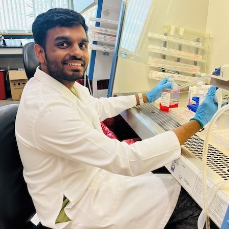 A scientist sitting at a lab bench