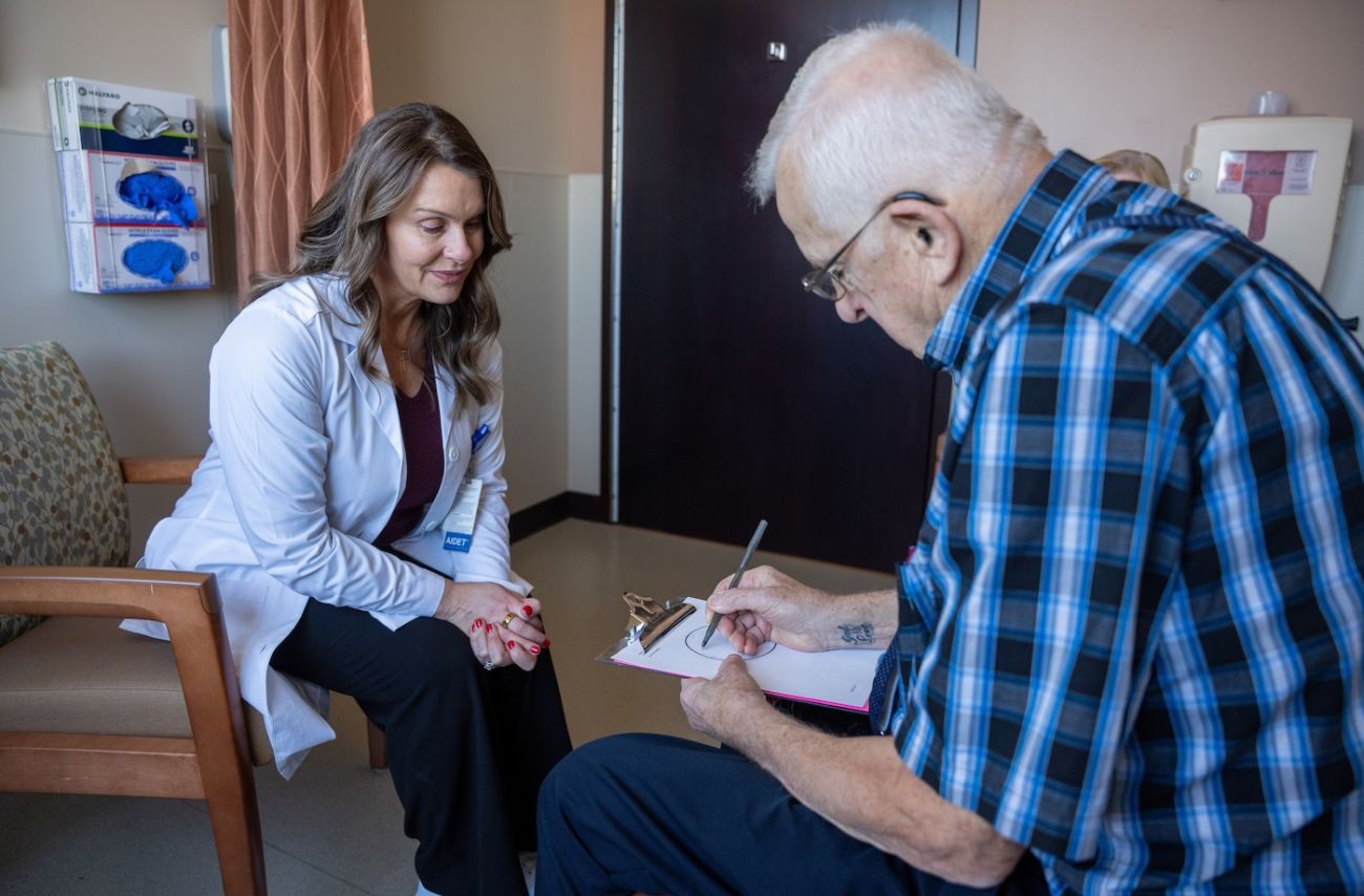 Older Adult Oncology Program patient draws a circle on a piece of paper with a physician watching on