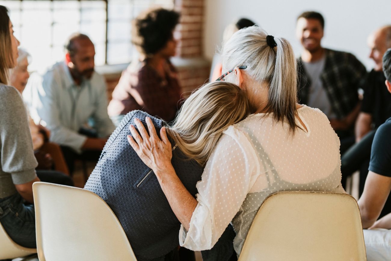 Two people embracing in a support group