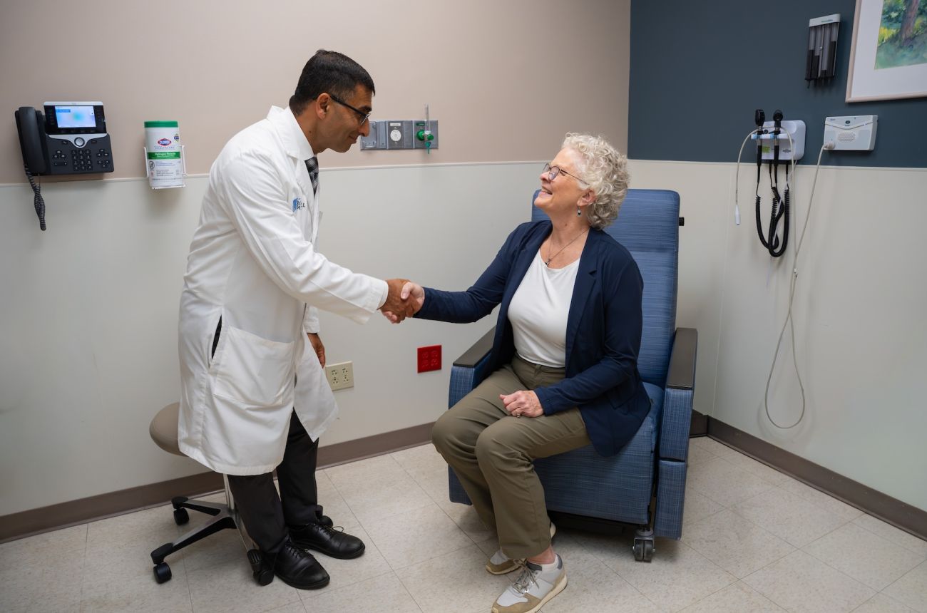 A doctor discuss treatment options with a patient in an exam room.