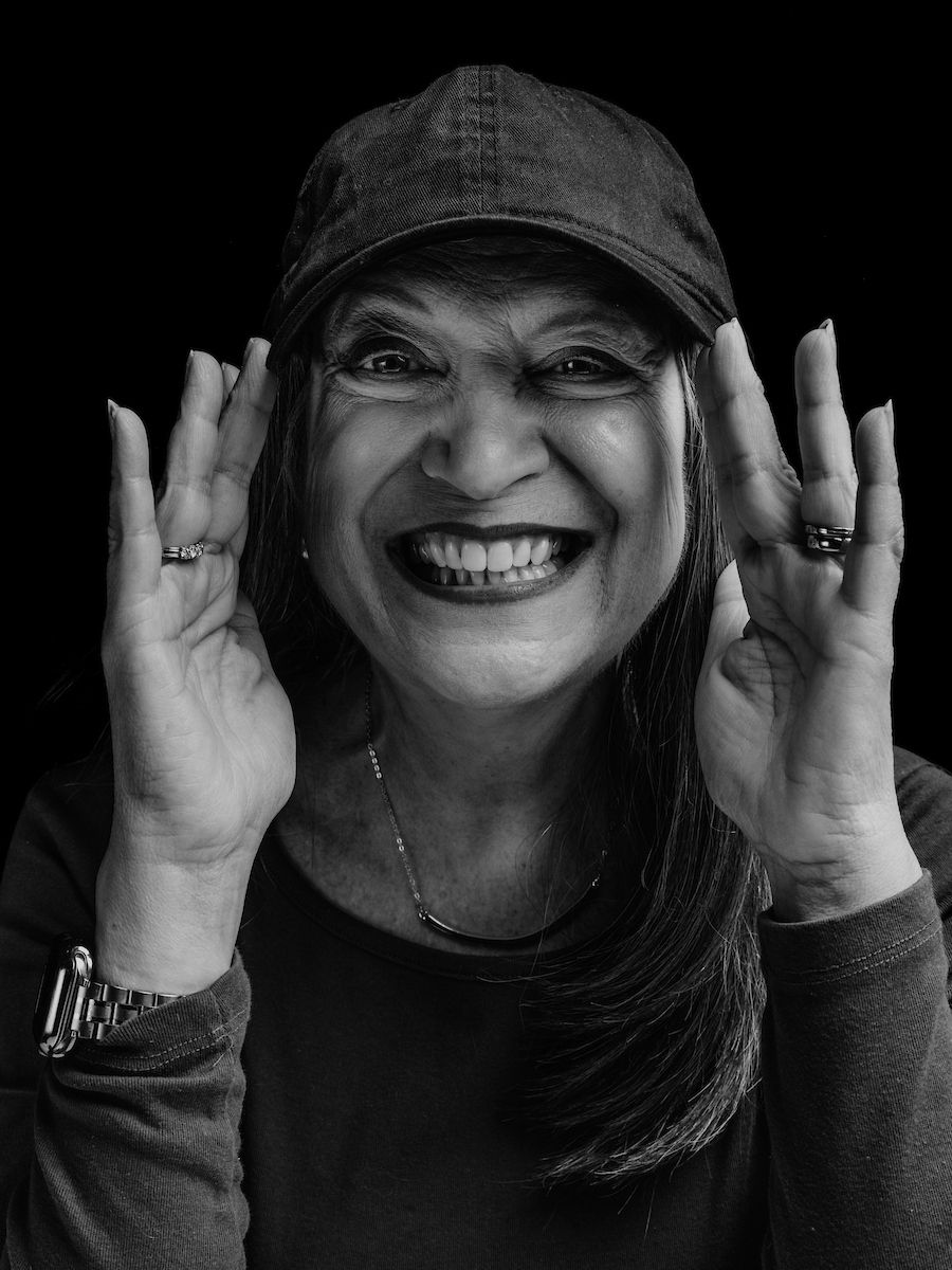 Black and white photo of Roswell Park patient Cheryl wearing a wig and hat to promote the Elevate Salon