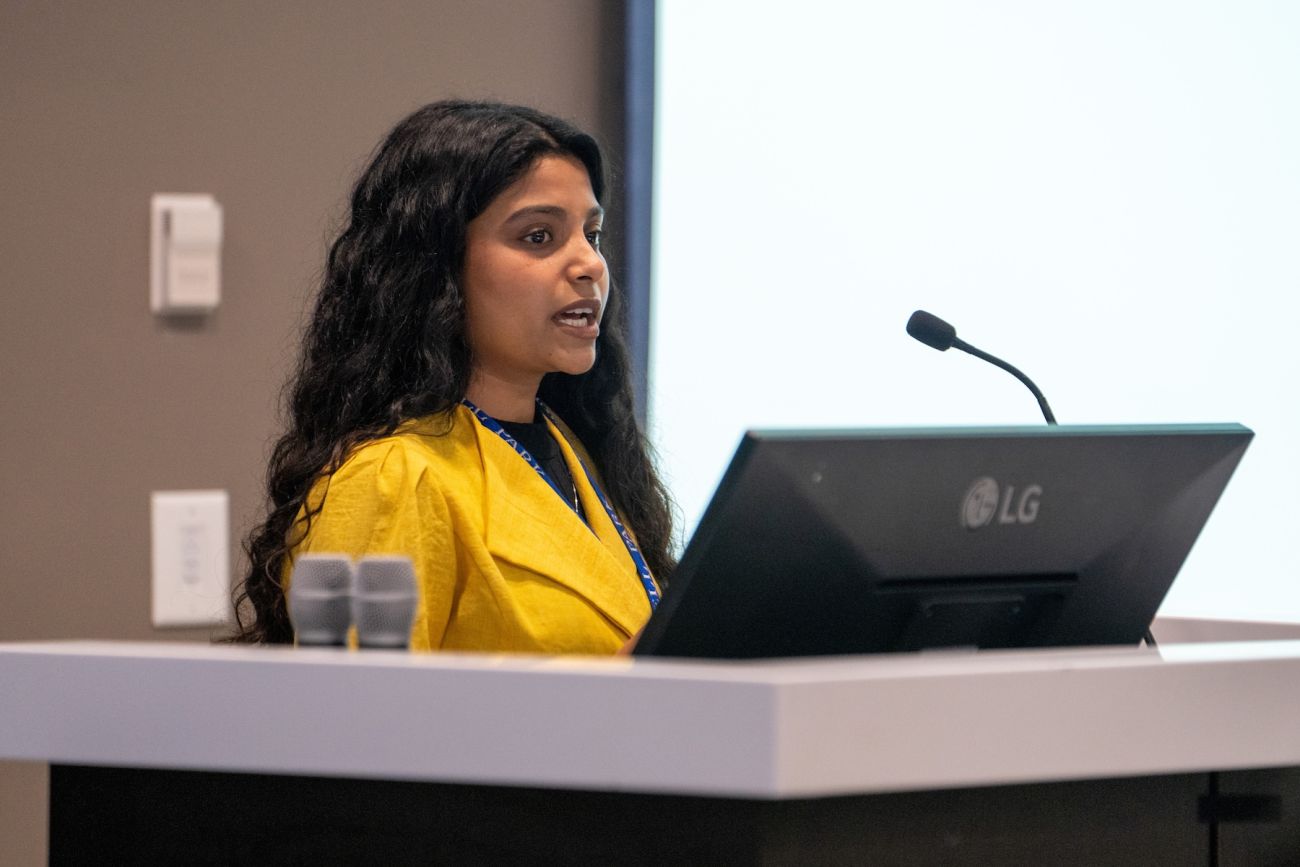 A woman gives a lecture from a podium
