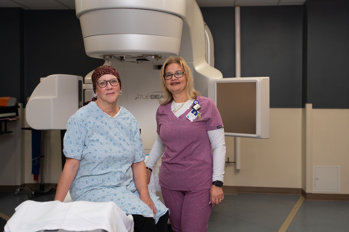 Patient Sue Banchich and Elizabeth Saez Marrero, radiation therapist, pose in radiation suite