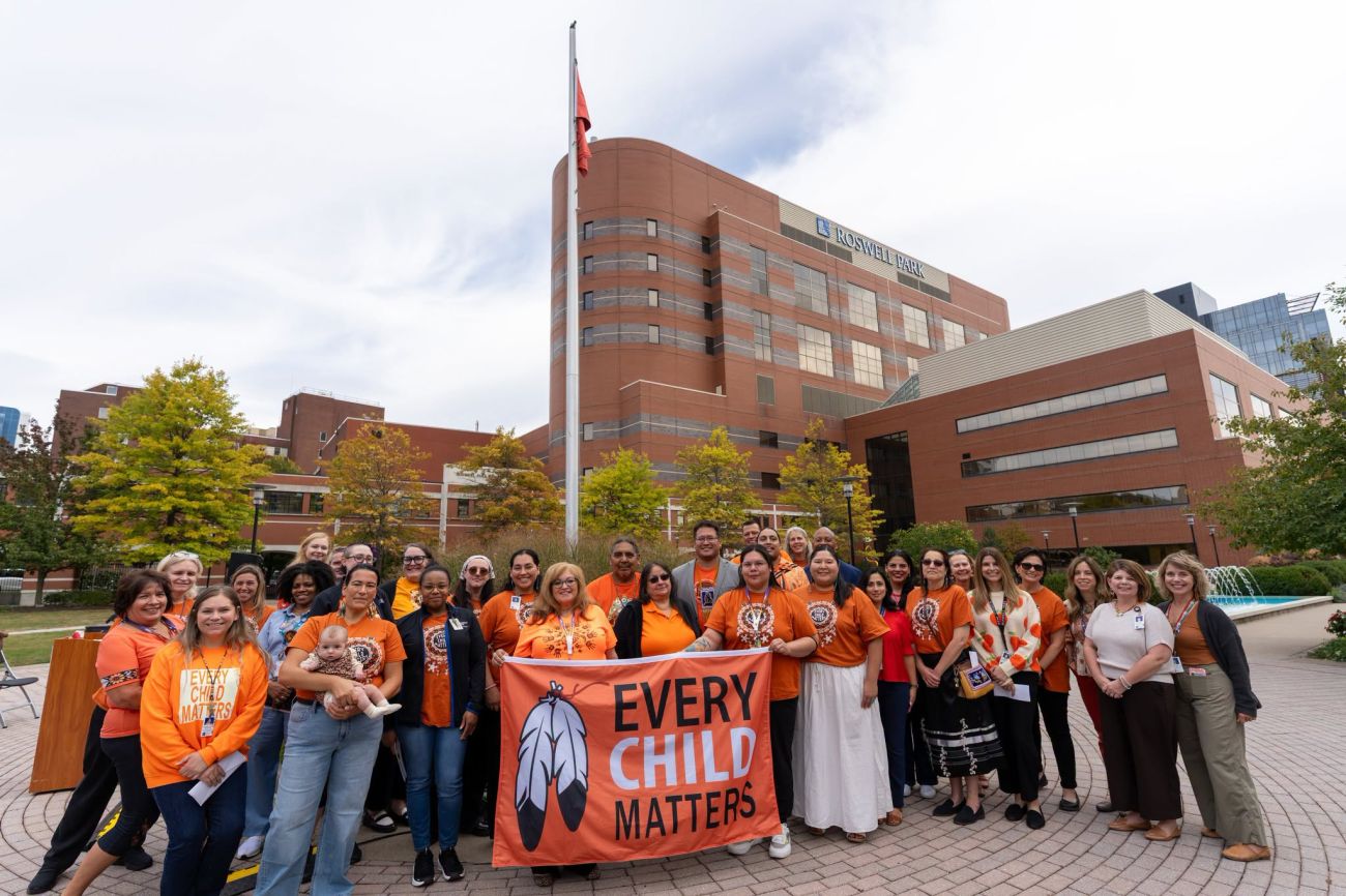 Los empleados de Roswell Park posan detrás de una pancarta con el lema "Cada niño importa" para conmemorar el Día de la Camisa Naranja.