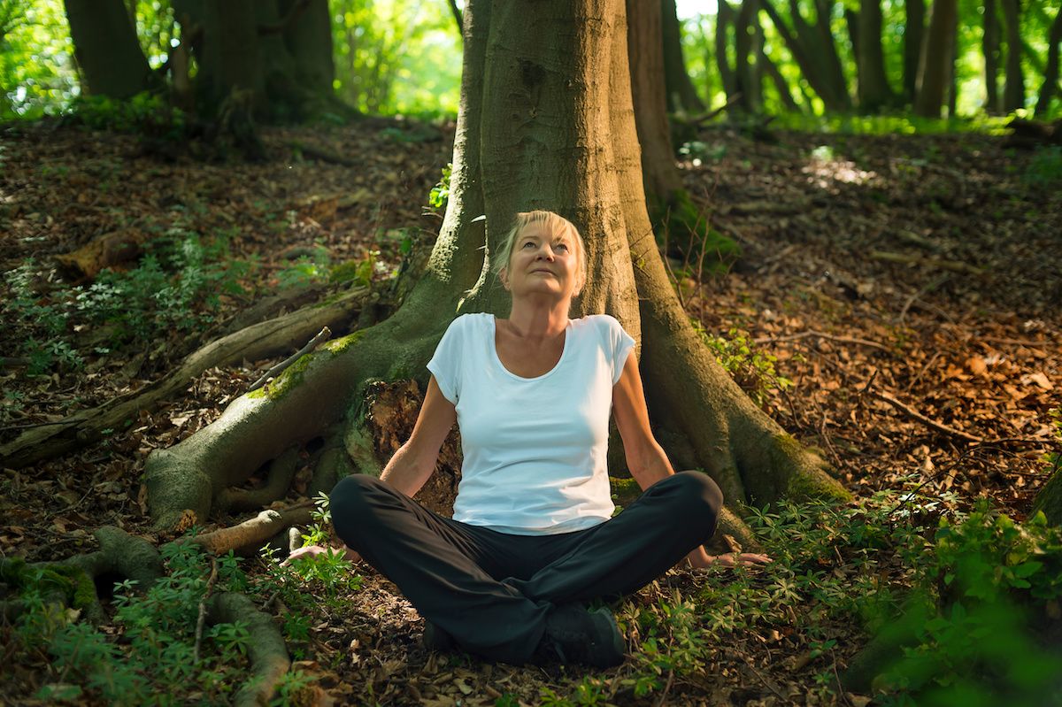 Lady relaxing under a tree in the forest