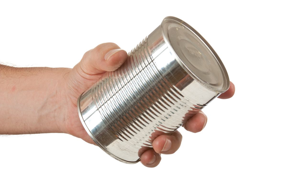 Hand holding a metal food can
