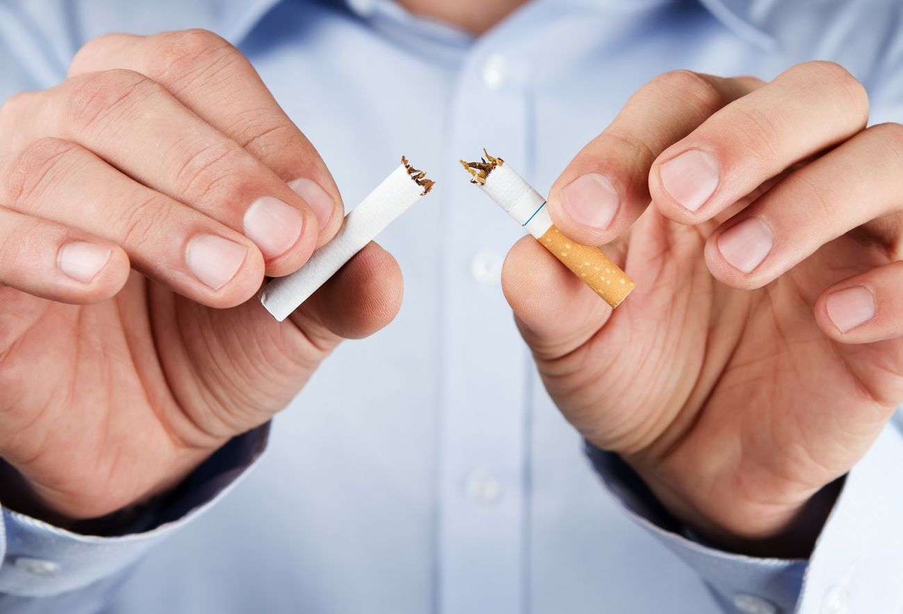 Close up of male hands holding cigarette broken in half