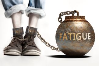 Leg attached to ball and chain with "fatigue" written on it