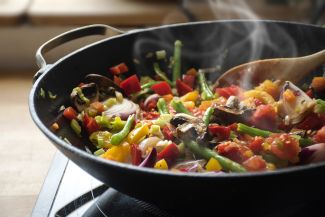 Stir-fry in a pan, with red and yellow peppers, red onion, green beans, mushrooms
