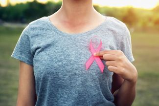Young woman holding a Breast Cancer Awareness Ribbon 