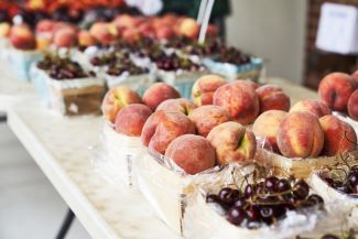 Peaches and cherries displayed at a farmers market
