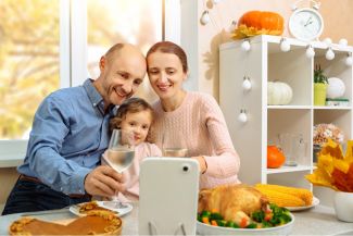 Family celebrating Thanksgiving with video call. 