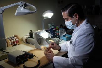 Dr. Frias at work creating a facial prosthesis at his lab bench