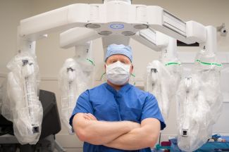 Steven Nurkin stands in front of the da Vinci robot he's used to perform 500 surgeries. 
