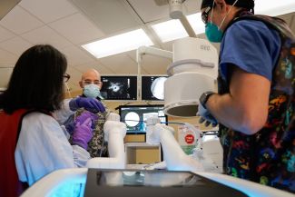 Two doctors and an endoscopy technician prepare for a procedure.