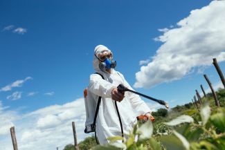 Agricultural worker spraying crops
