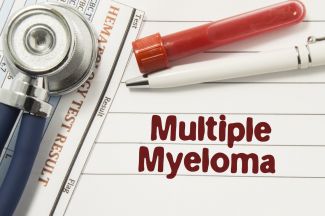 "Multiple Myeloma" written on a sheet of paper underneath a pen, stethoscope, and vial of blood