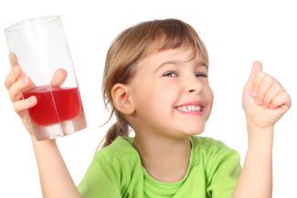 Young girl holding a glass of red fruit punch