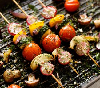 Vegetable shishkebabs cooking on a grill